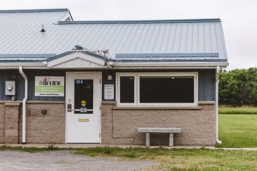 Small building with green field behind 