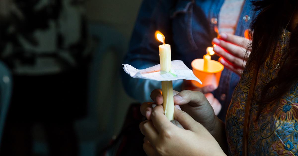 Image of candle held in a person's hands